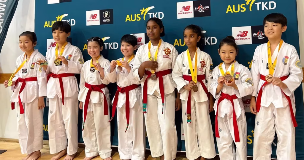 Group of young taekwondo students from Brisbane proudly wearing medals at an AUS TKD competition